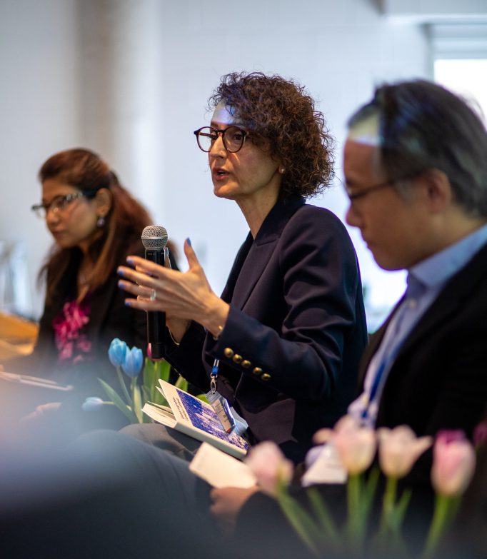 Tuba Bircan speaking into a microphone on a conference panel